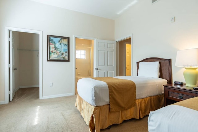 carpeted bedroom with ensuite bath, a closet, and a spacious closet