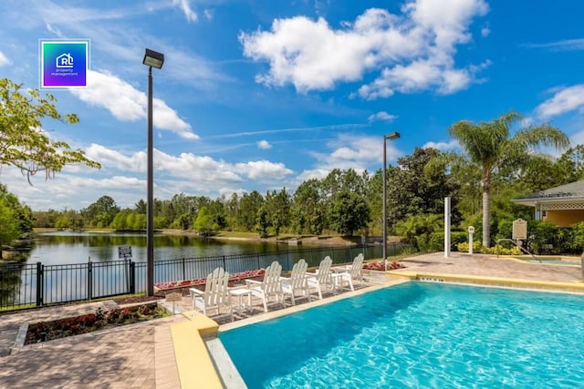 view of swimming pool with a water view and a patio area