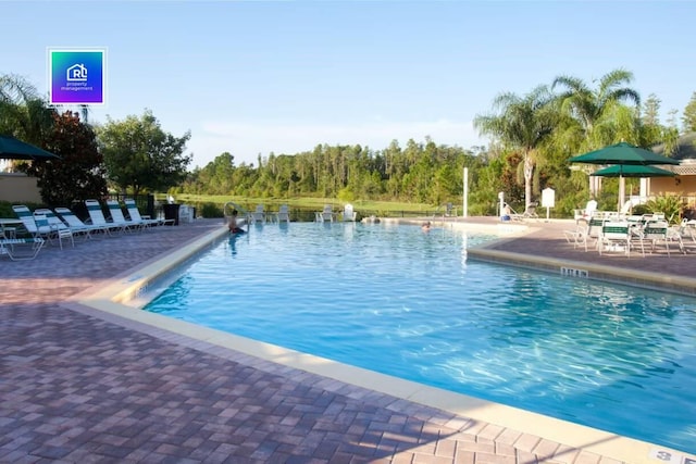 view of pool with a water view and a patio area