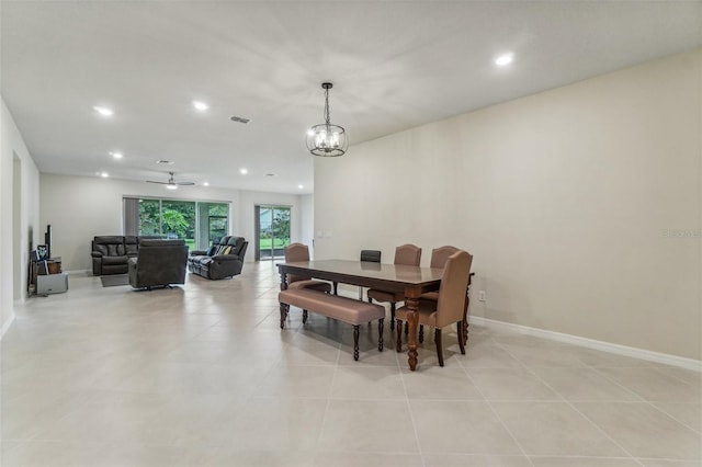 tiled dining area with ceiling fan with notable chandelier