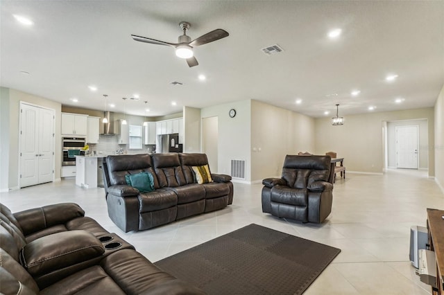 living room with light tile patterned floors and ceiling fan with notable chandelier