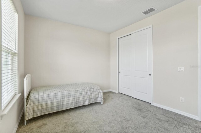 bedroom featuring a closet and light colored carpet