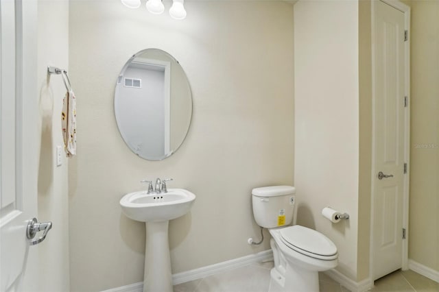 bathroom featuring tile patterned flooring, toilet, and sink