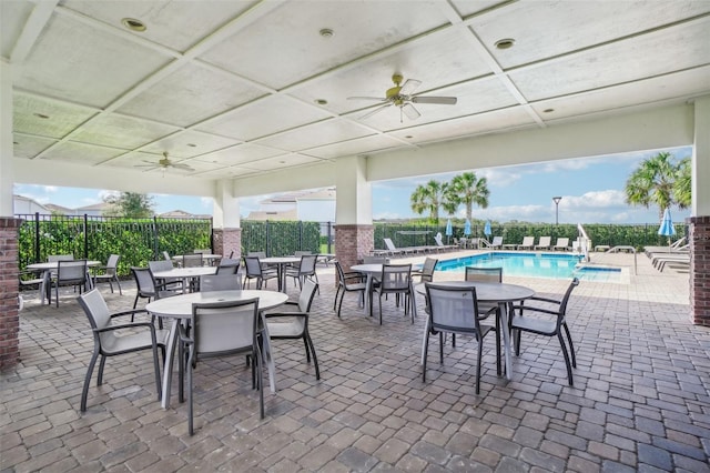 view of patio with ceiling fan and a community pool