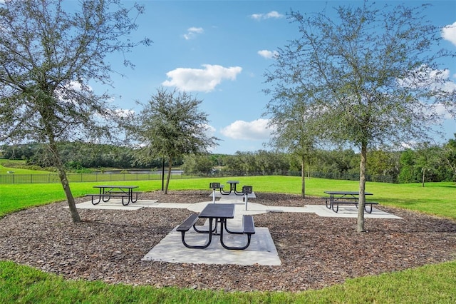 view of property's community with a patio and a lawn