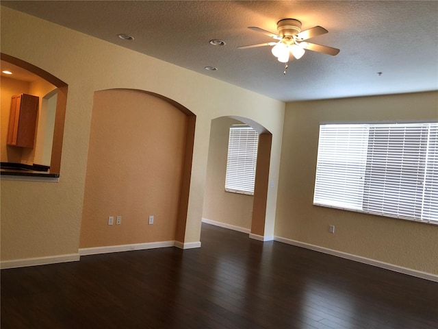 spare room featuring a textured ceiling, dark wood-type flooring, and ceiling fan