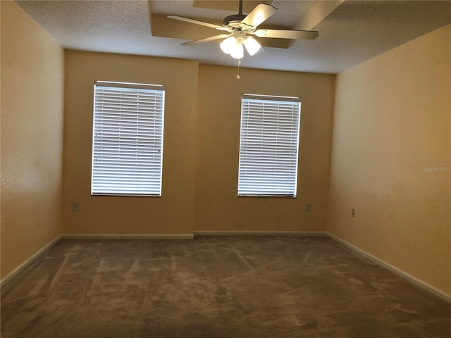 unfurnished room featuring ceiling fan, a textured ceiling, and dark carpet