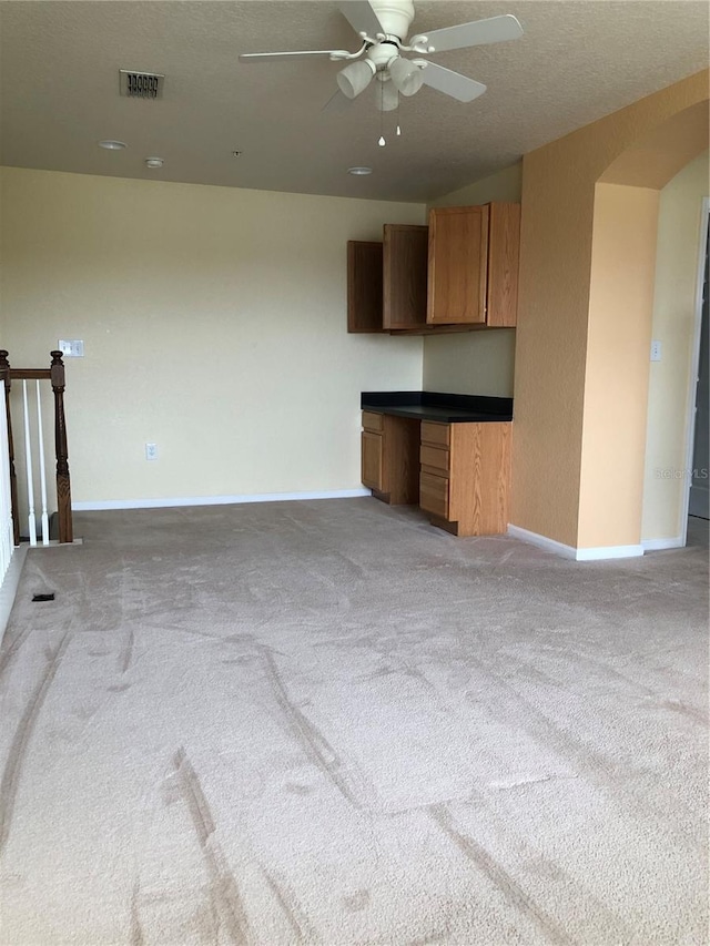 unfurnished living room with ceiling fan and light carpet