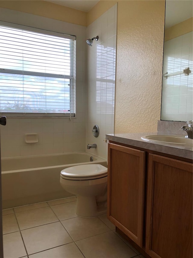 full bathroom featuring vanity, tile patterned flooring, tiled shower / bath, and toilet