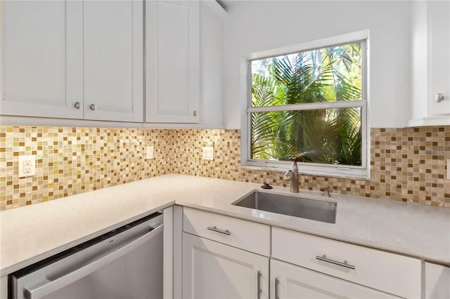 kitchen featuring white cabinets, dishwasher, and tasteful backsplash