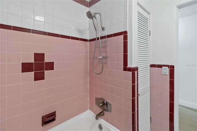 bathroom featuring tiled shower / bath combo and hardwood / wood-style flooring