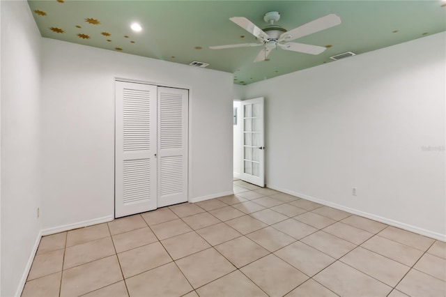 unfurnished bedroom featuring light tile patterned flooring, ceiling fan, and a closet