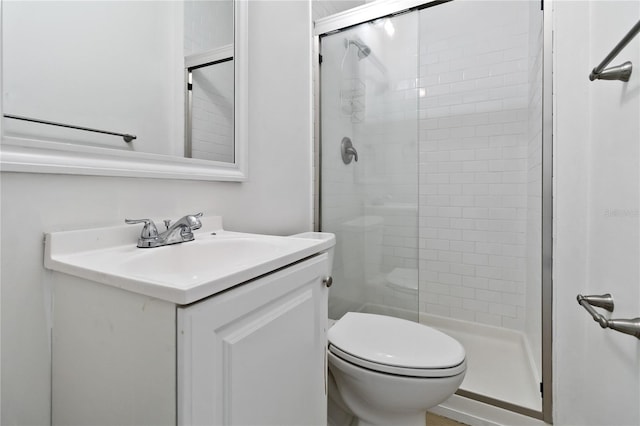 bathroom with vanity, toilet, and a shower with door