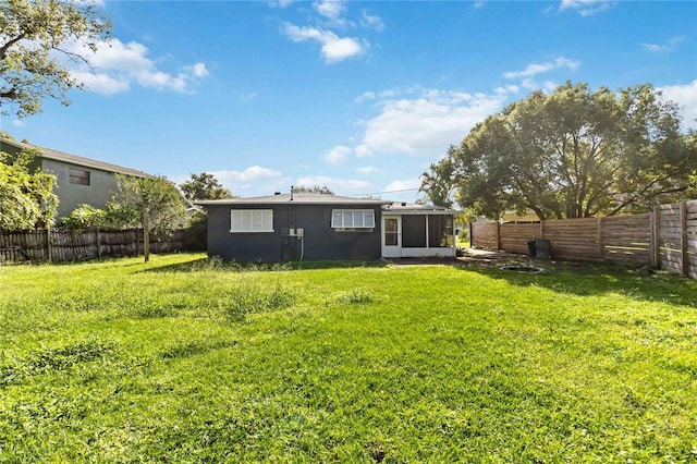 rear view of property with a sunroom and a yard