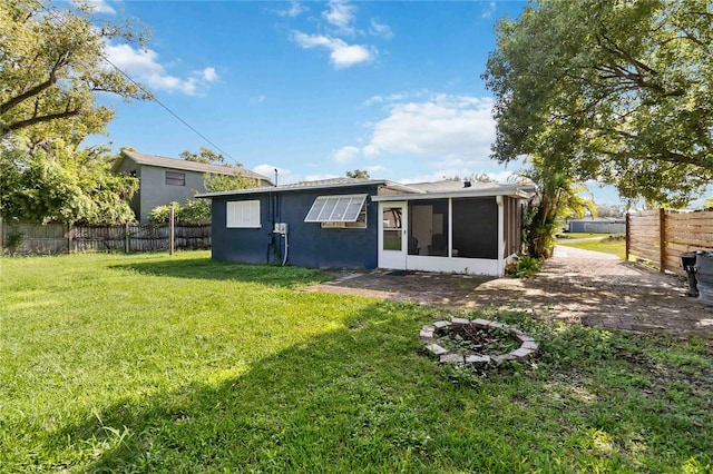 rear view of house featuring a lawn and a sunroom