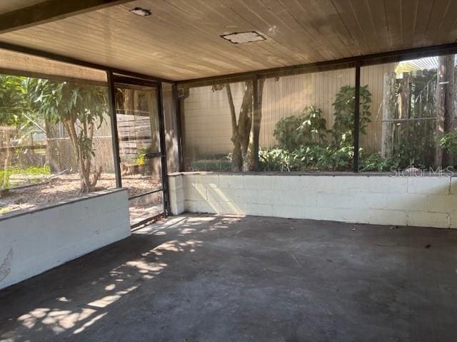 unfurnished sunroom with plenty of natural light and wooden ceiling