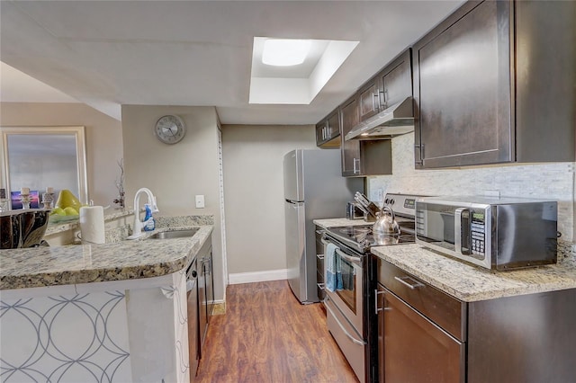 kitchen with stainless steel appliances, sink, light stone counters, dark brown cabinets, and dark wood-type flooring