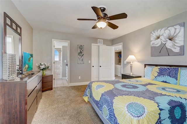 bedroom featuring ceiling fan, ensuite bath, and light colored carpet