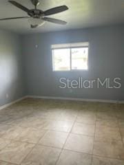 empty room featuring tile patterned floors and ceiling fan