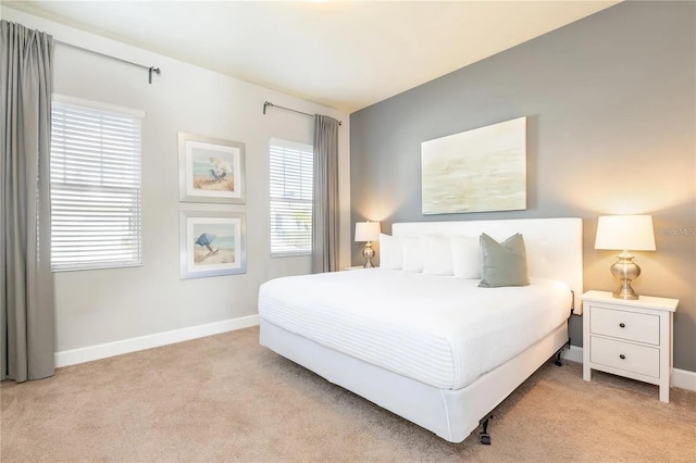 bedroom featuring light carpet and multiple windows