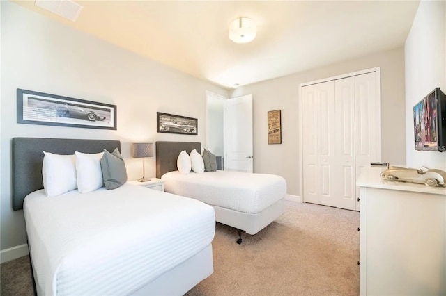 bedroom featuring light carpet and a closet