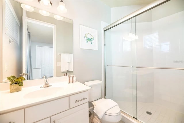 bathroom with vanity, a shower with shower door, and toilet