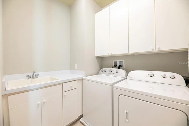 clothes washing area featuring cabinets, washer and dryer, and sink