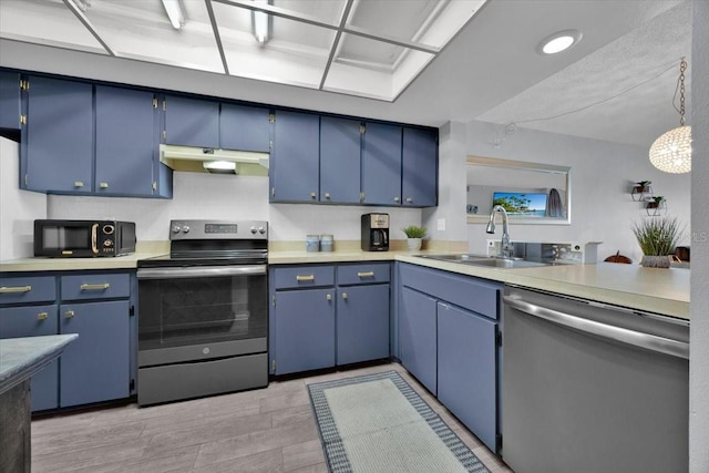 kitchen with hanging light fixtures, stainless steel appliances, sink, and blue cabinetry