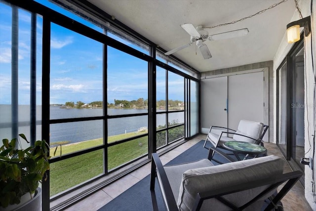 sunroom / solarium featuring a water view and ceiling fan