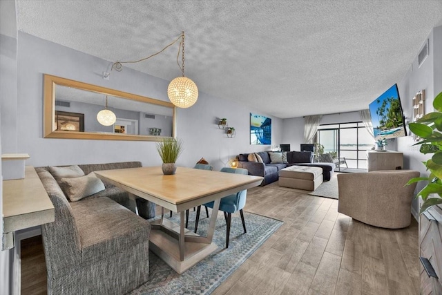 dining room with hardwood / wood-style floors and a textured ceiling