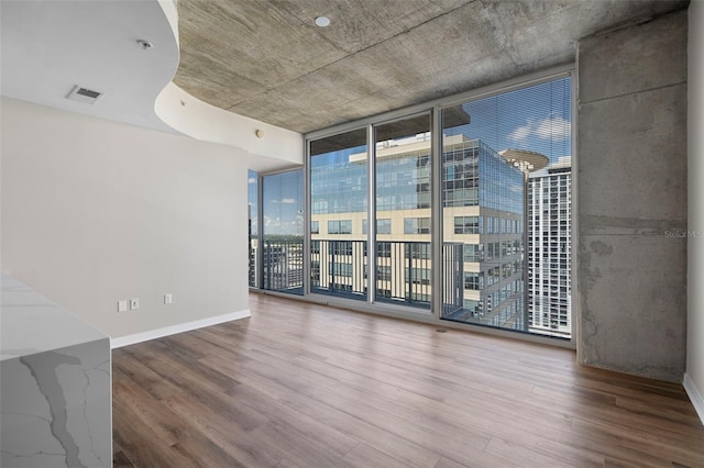 unfurnished room with hardwood / wood-style flooring and floor to ceiling windows