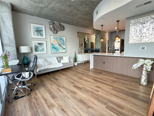 living room featuring light wood-type flooring and sink