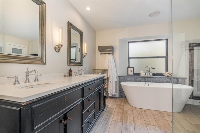 bathroom featuring vanity, hardwood / wood-style flooring, and a bathing tub