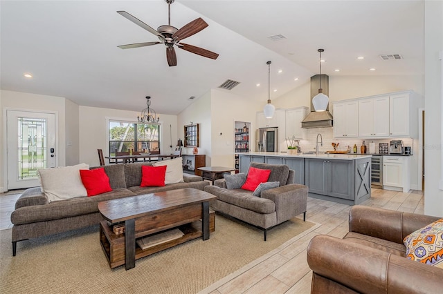 living room featuring ceiling fan with notable chandelier, sink, light hardwood / wood-style flooring, vaulted ceiling, and beverage cooler