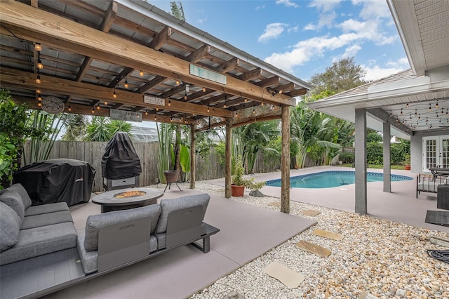 view of pool with a grill, a patio, and an outdoor fire pit