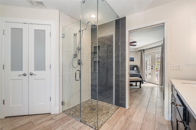 bathroom featuring french doors, vanity, a shower with door, and ceiling fan