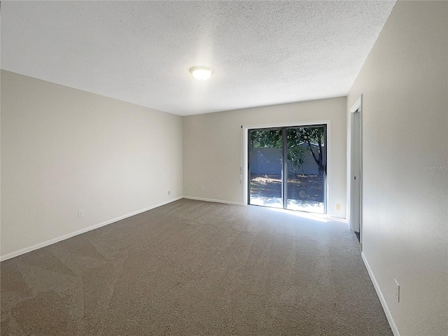 empty room with a textured ceiling and carpet