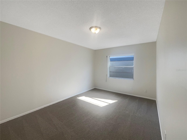 carpeted empty room featuring a textured ceiling