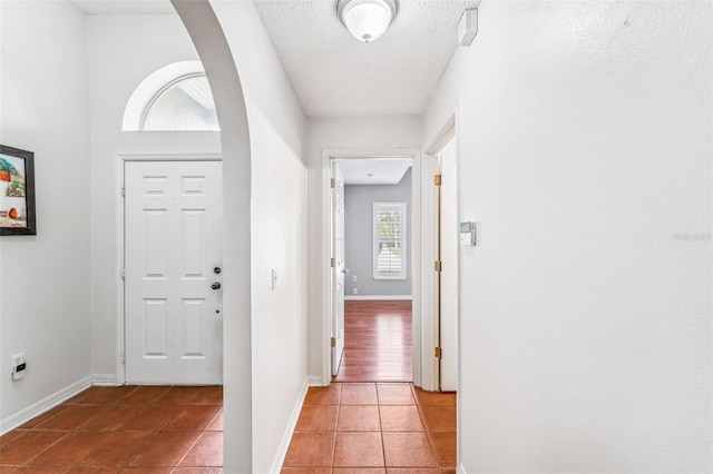 tiled foyer entrance featuring a textured ceiling