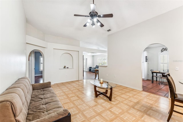 living room featuring ceiling fan, a healthy amount of sunlight, and parquet flooring