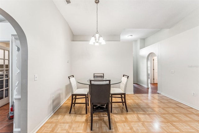 dining room featuring parquet floors and a chandelier