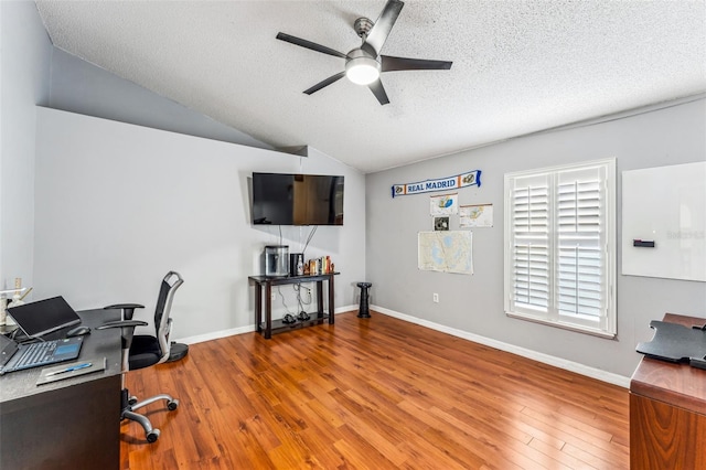 office area with a textured ceiling, hardwood / wood-style flooring, ceiling fan, and lofted ceiling