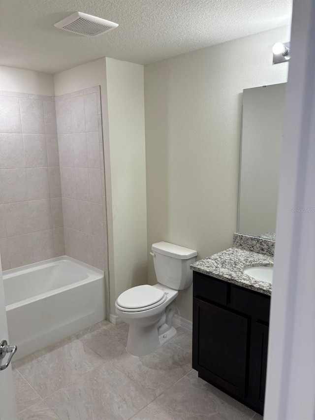 full bathroom featuring tile patterned flooring, a textured ceiling, toilet, vanity, and tiled shower / bath