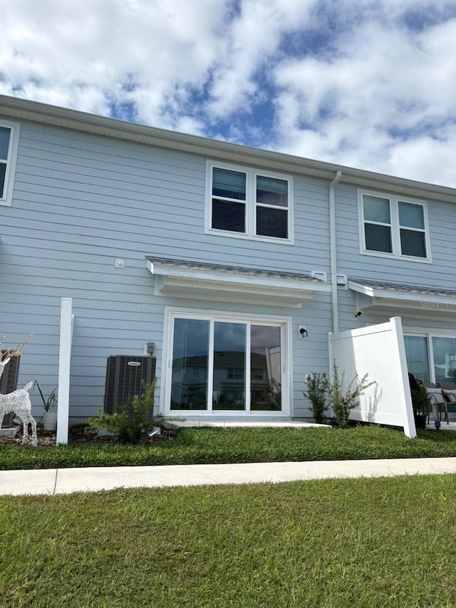 back of house with a lawn and central AC unit