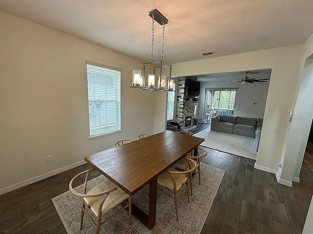 dining area with a textured ceiling, dark hardwood / wood-style floors, and ceiling fan