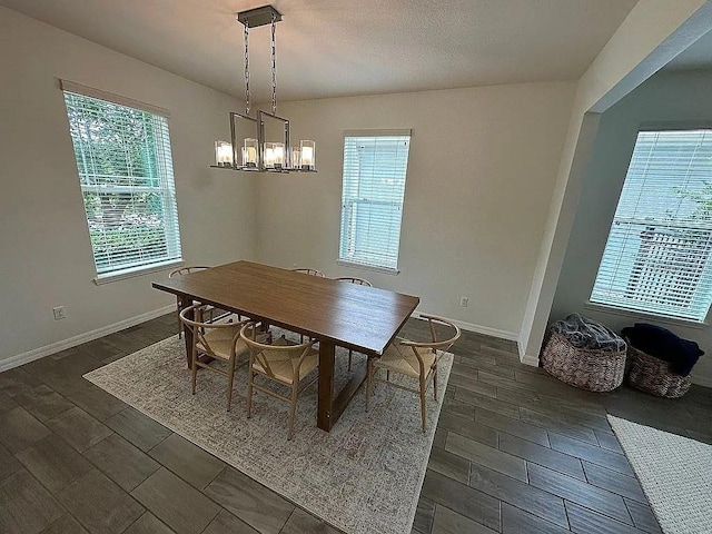 dining room with dark hardwood / wood-style floors and an inviting chandelier