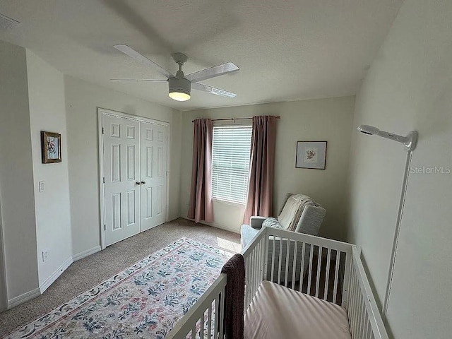 bedroom with ceiling fan, a closet, carpet, and a nursery area