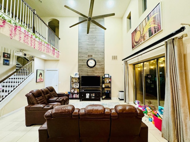 living room featuring ceiling fan, a towering ceiling, and light tile patterned floors