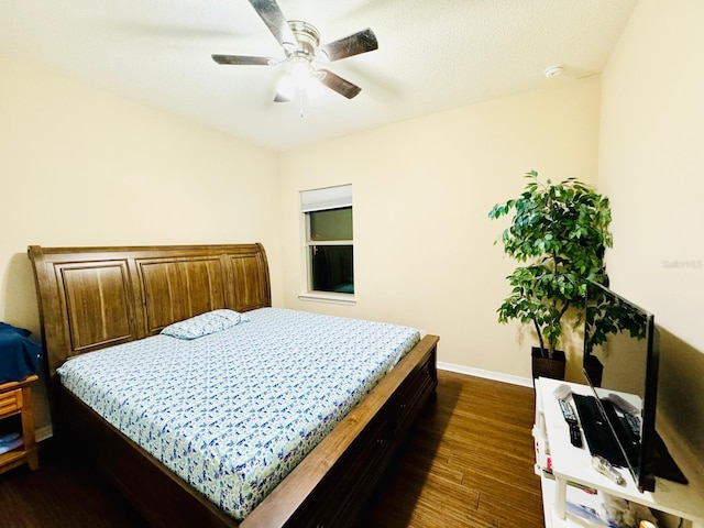 bedroom with ceiling fan, dark wood-type flooring, and a textured ceiling