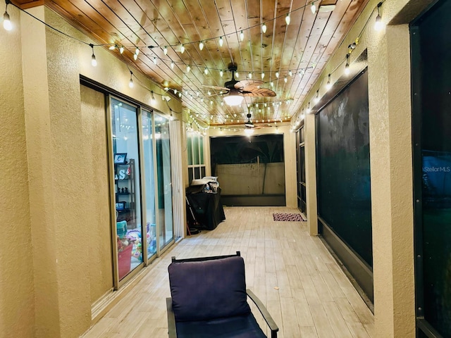 corridor with light wood-type flooring and wooden ceiling